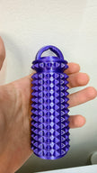 Hand holding purple spiky massager with storage lid for crochet and knitting hand care