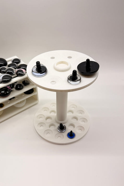 Close-up of the Safety Eye Painter holding standard and sinker safety eyes, designed for painting, drying, and organizing amigurumi eyes.