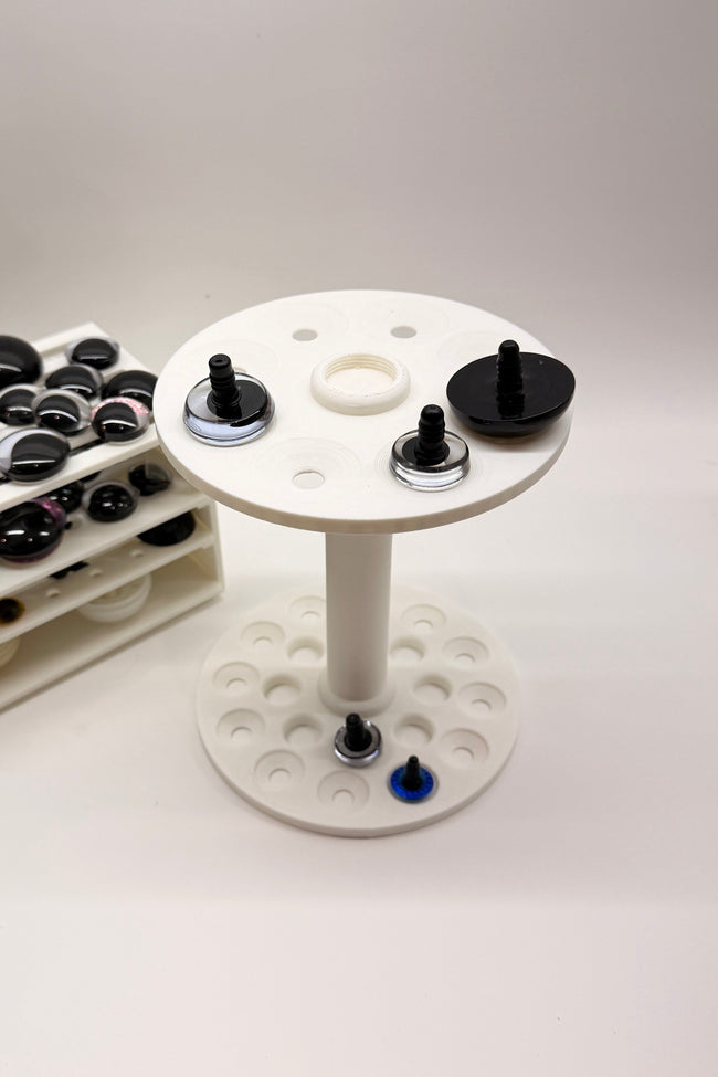 Close-up of the Safety Eye Painter holding standard and sinker safety eyes, designed for painting, drying, and organizing amigurumi eyes.