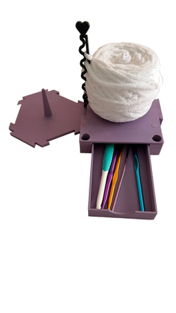 Build-A-Spin modular yarn spinner with purple base, white yarn ball, and sliding crochet hook storage drawer on transparent background