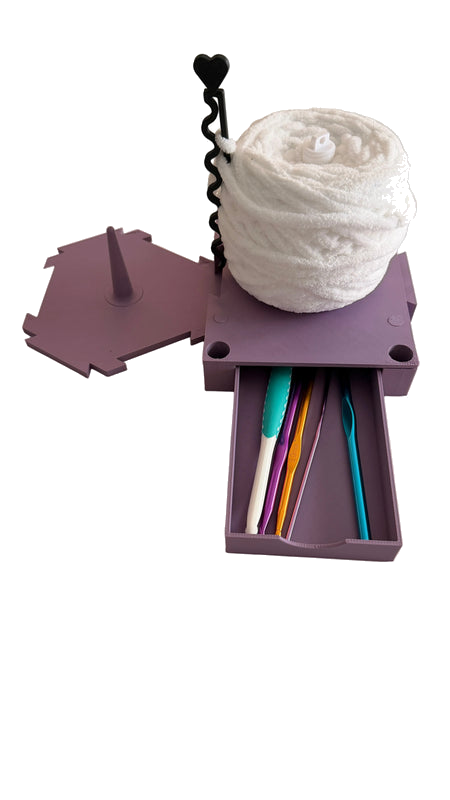 Build-A-Spin modular yarn spinner with purple base, white yarn ball, and sliding crochet hook storage drawer on transparent background